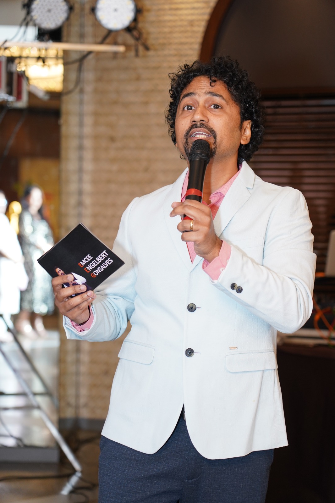 Engelbert Gonsalves on stage with a microphone